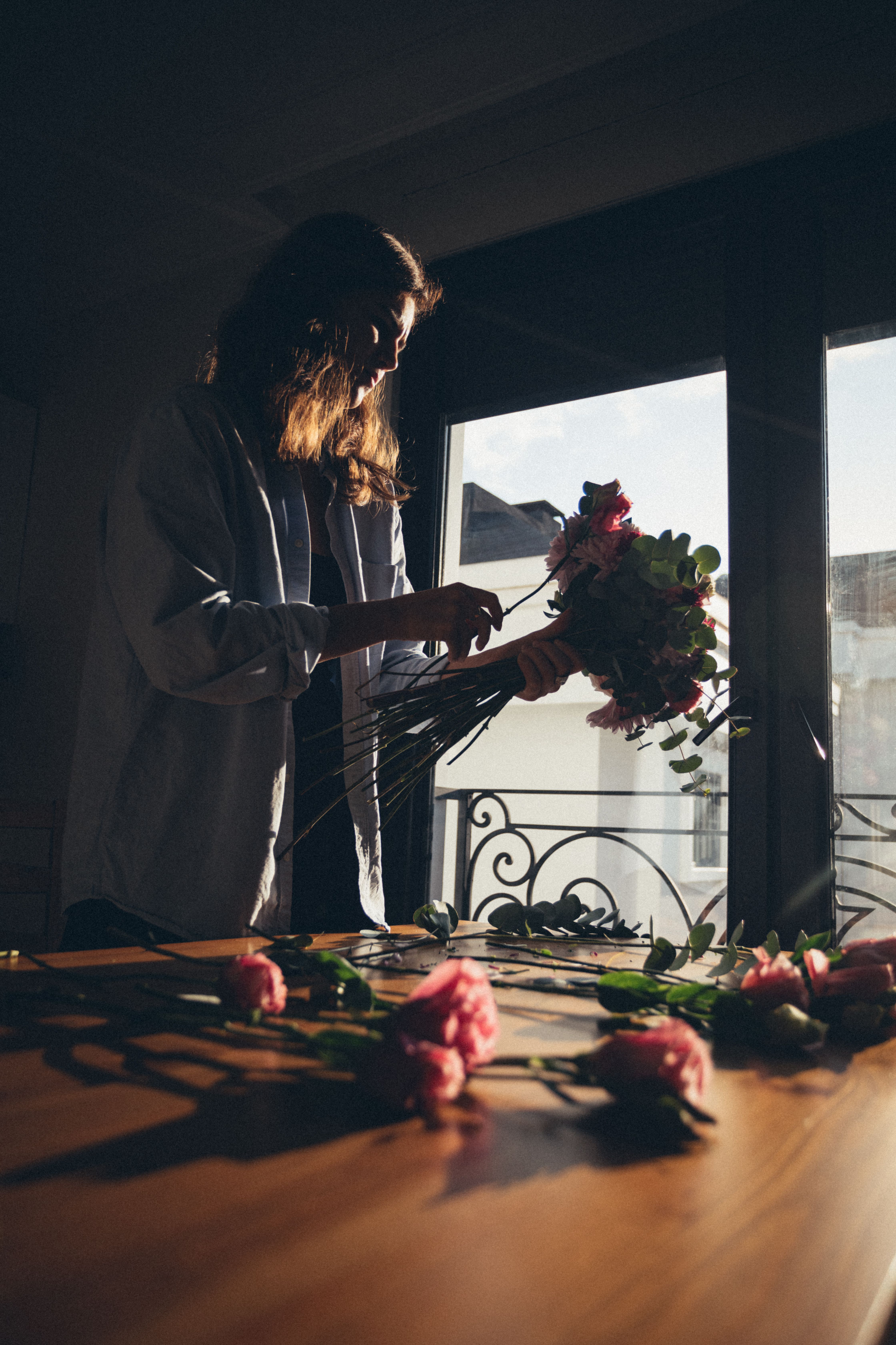 Moody floral centerpiece and old books in warm evening sunlight